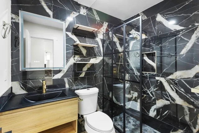 a bathroom with a sink mirror vanity and toilet