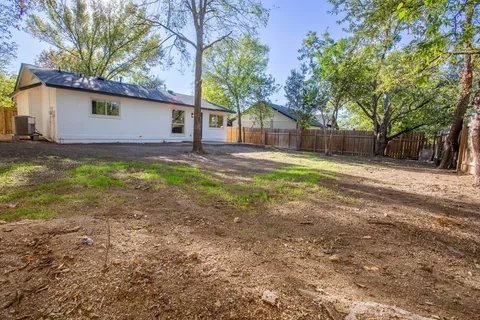a backyard of a house with barbeque oven table and chairs