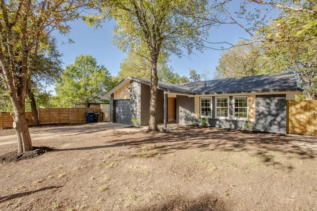 a view of a house with a patio and a yard