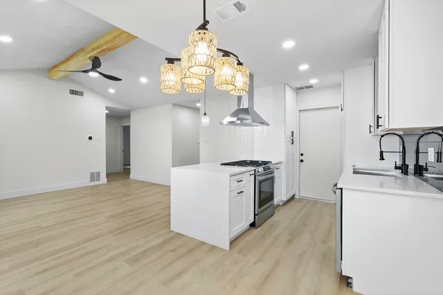 a kitchen with stainless steel appliances a sink cabinets and wooden floor