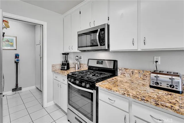 a kitchen with granite countertop white cabinets and appliances
