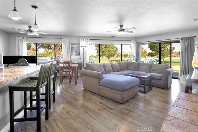 a kitchen with granite countertop a sink a counter top space and living room view