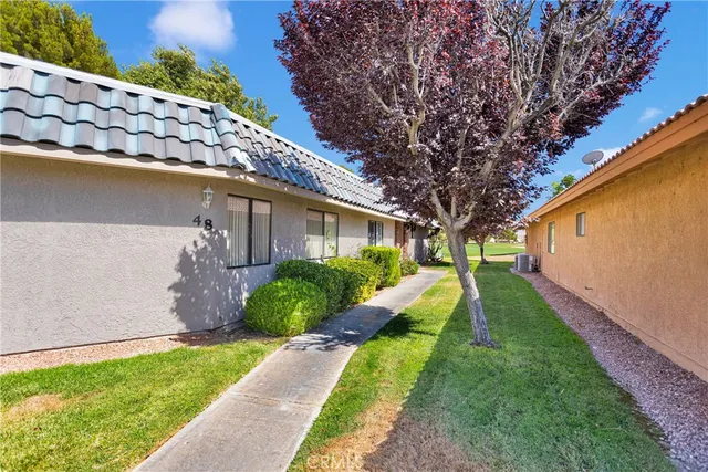 a front view of house with swimming pool and green space
