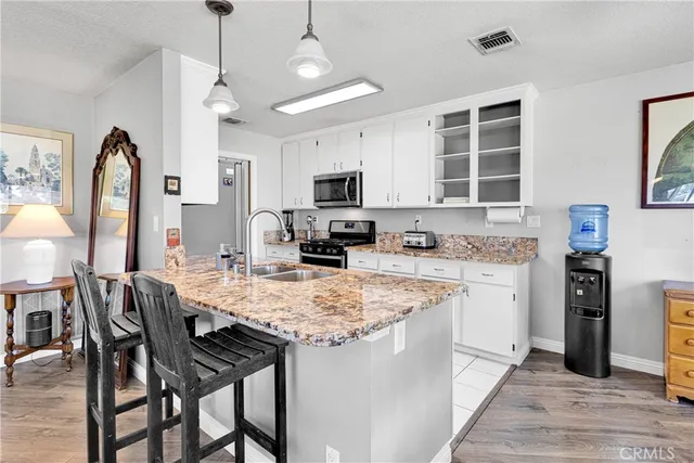 a kitchen with stainless steel appliances granite countertop a stove top oven a refrigerator a sink and a refrigerator