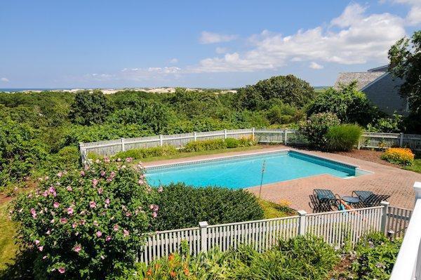 a view of a swimming pool with a patio and a yard