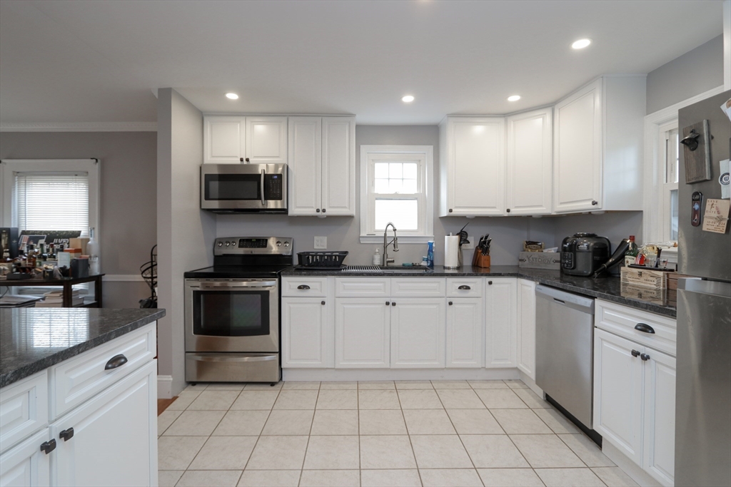 31 Thornton Street Springfield, MA 01104 - Photo 12 of 32 a kitchen with white cabinets sink and stainless steel appliances
