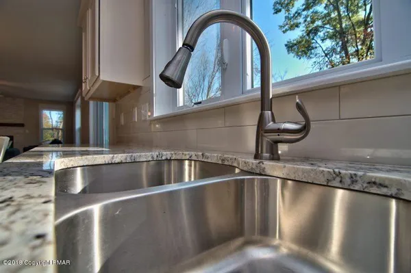 a kitchen with stainless steel appliances granite countertop a sink a stove and a refrigerator