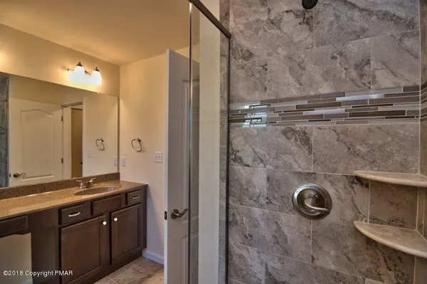 a bathroom with a granite countertop toilet sink and mirror
