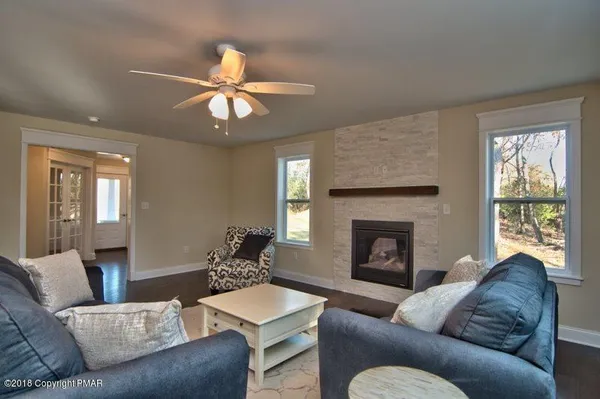 a living room with furniture a fireplace and a window