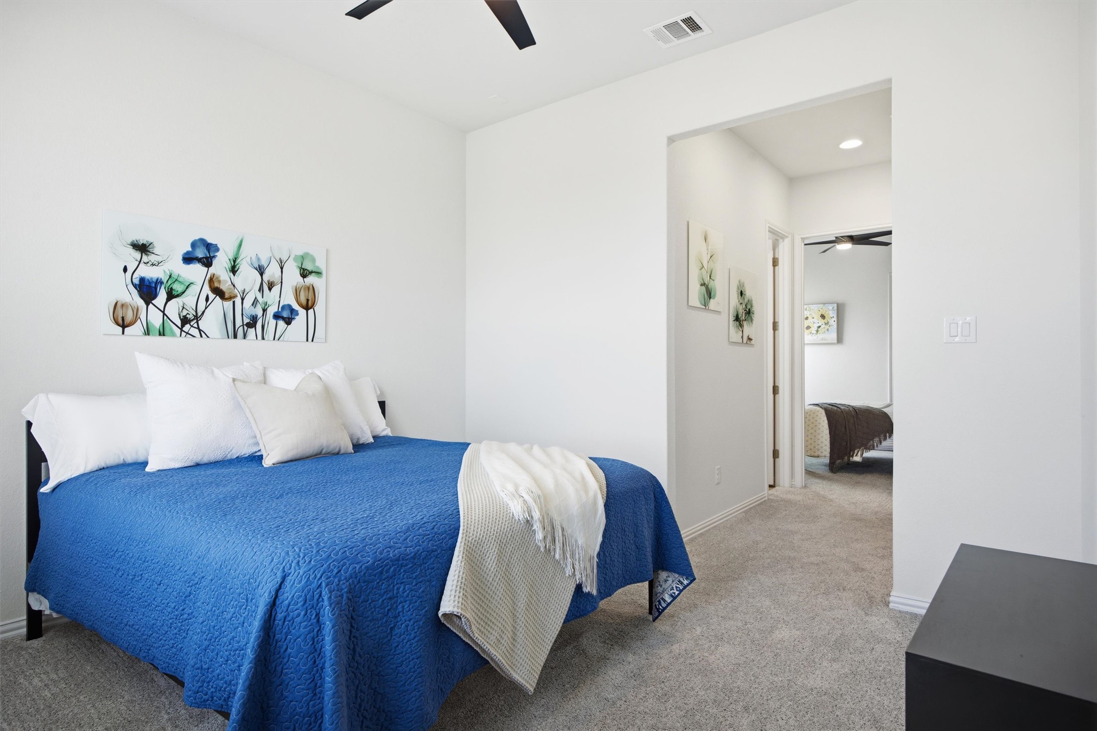 192 Raptor Beak Way Cedar Creek, TX 78612 - Photo 23 of 38 Carpeted bedroom featuring a ceiling fan with light, white walls, and a recessed lighting fixture in the hallway
