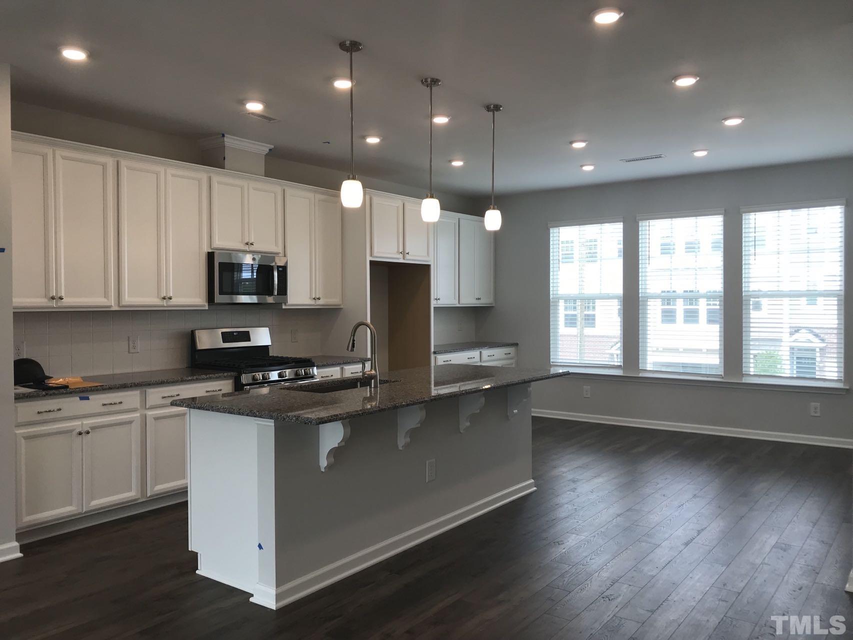 1258 Commack Drive Durham, NC 27703 - Photo 52 of 68 a kitchen with stainless steel appliances granite countertop a stove a sink a refrigerator and white cabinets