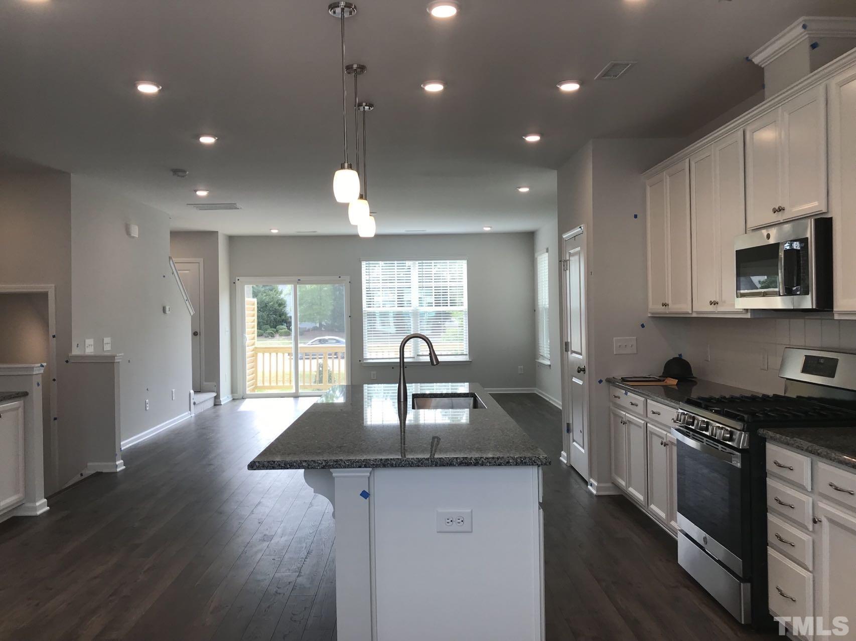 1258 Commack Drive Durham, NC 27703 - Photo 55 of 68 a kitchen with granite countertop kitchen island a sink appliances and a counter top space