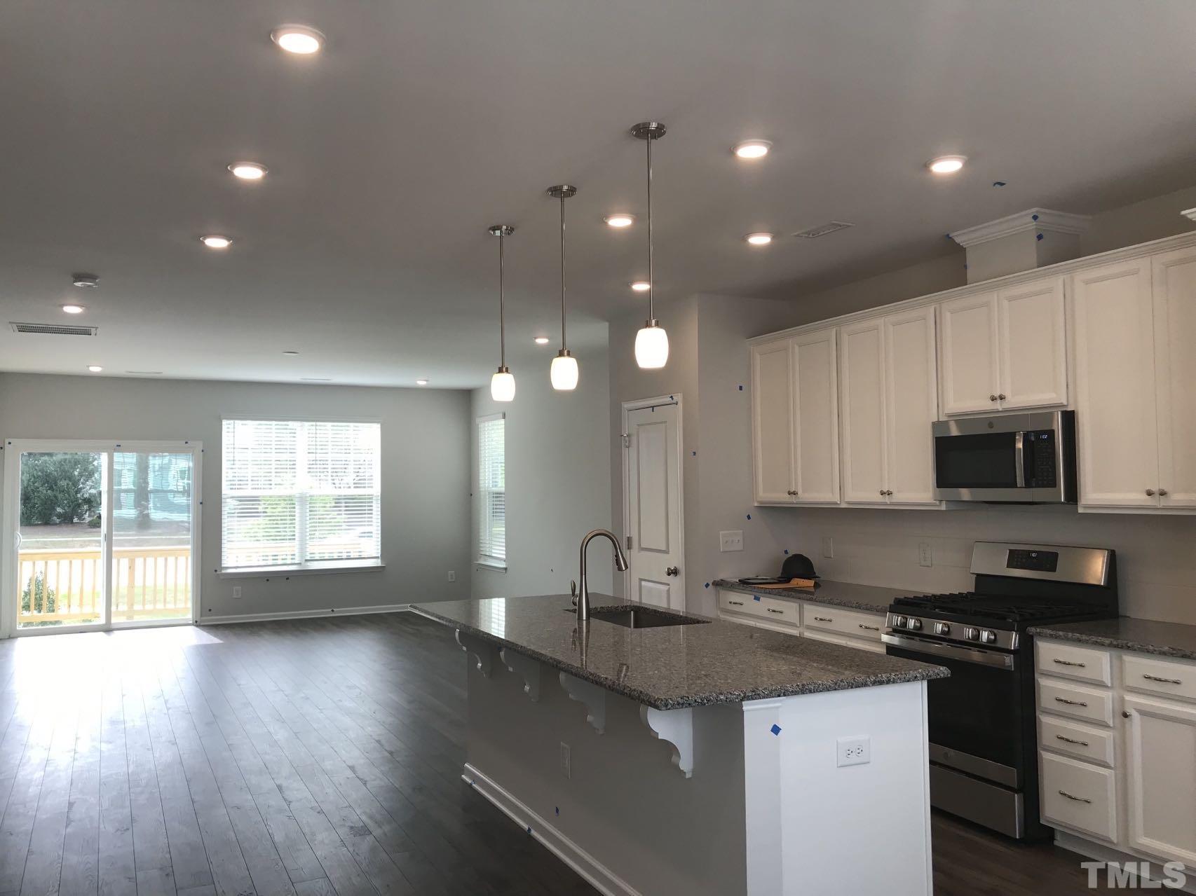 1258 Commack Drive Durham, NC 27703 - Photo 56 of 68 a kitchen with stainless steel appliances granite countertop a sink a stove and a wooden floors