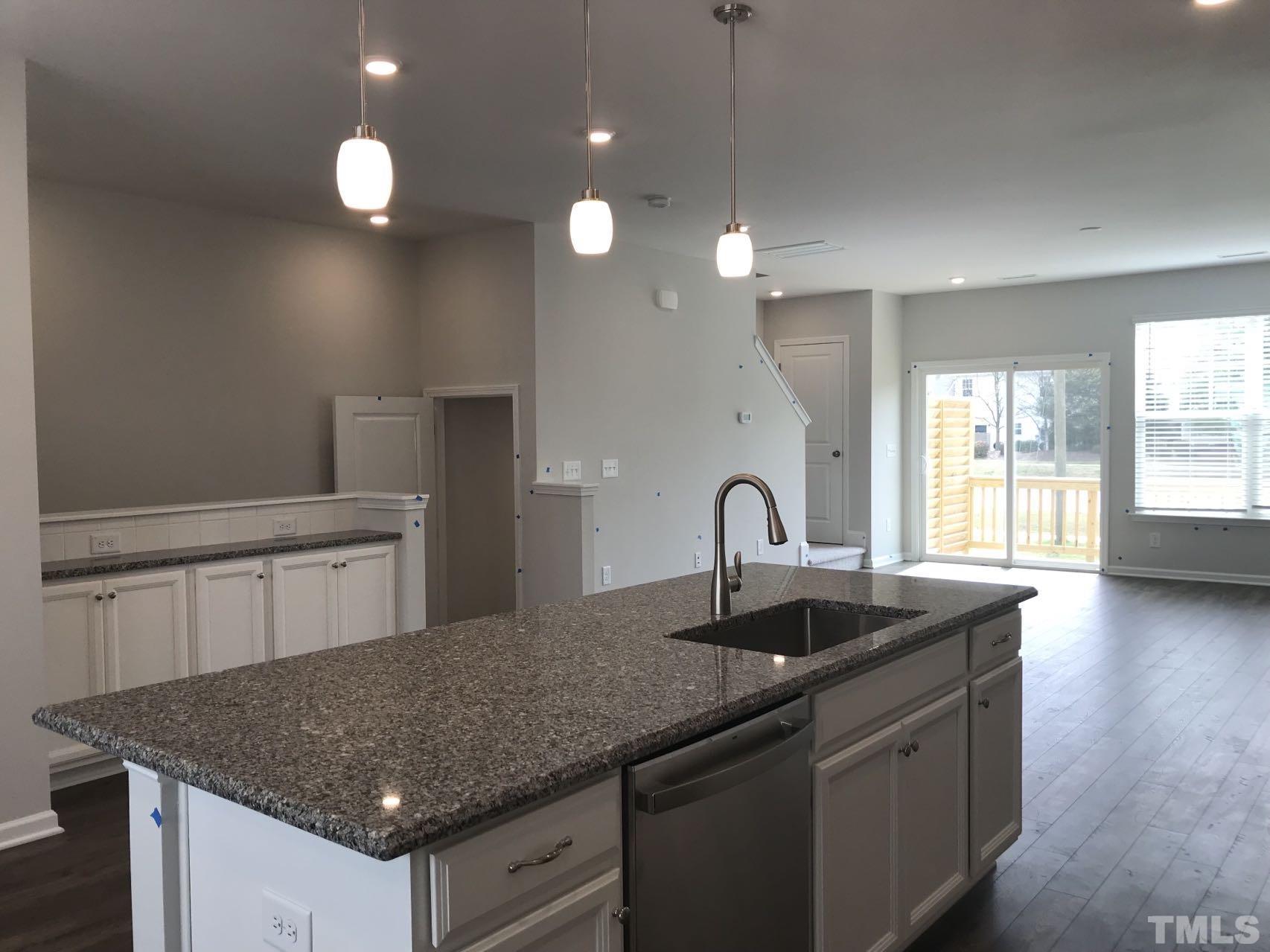 1258 Commack Drive Durham, NC 27703 - Photo 57 of 68 a kitchen with granite countertop a sink and white cabinets
