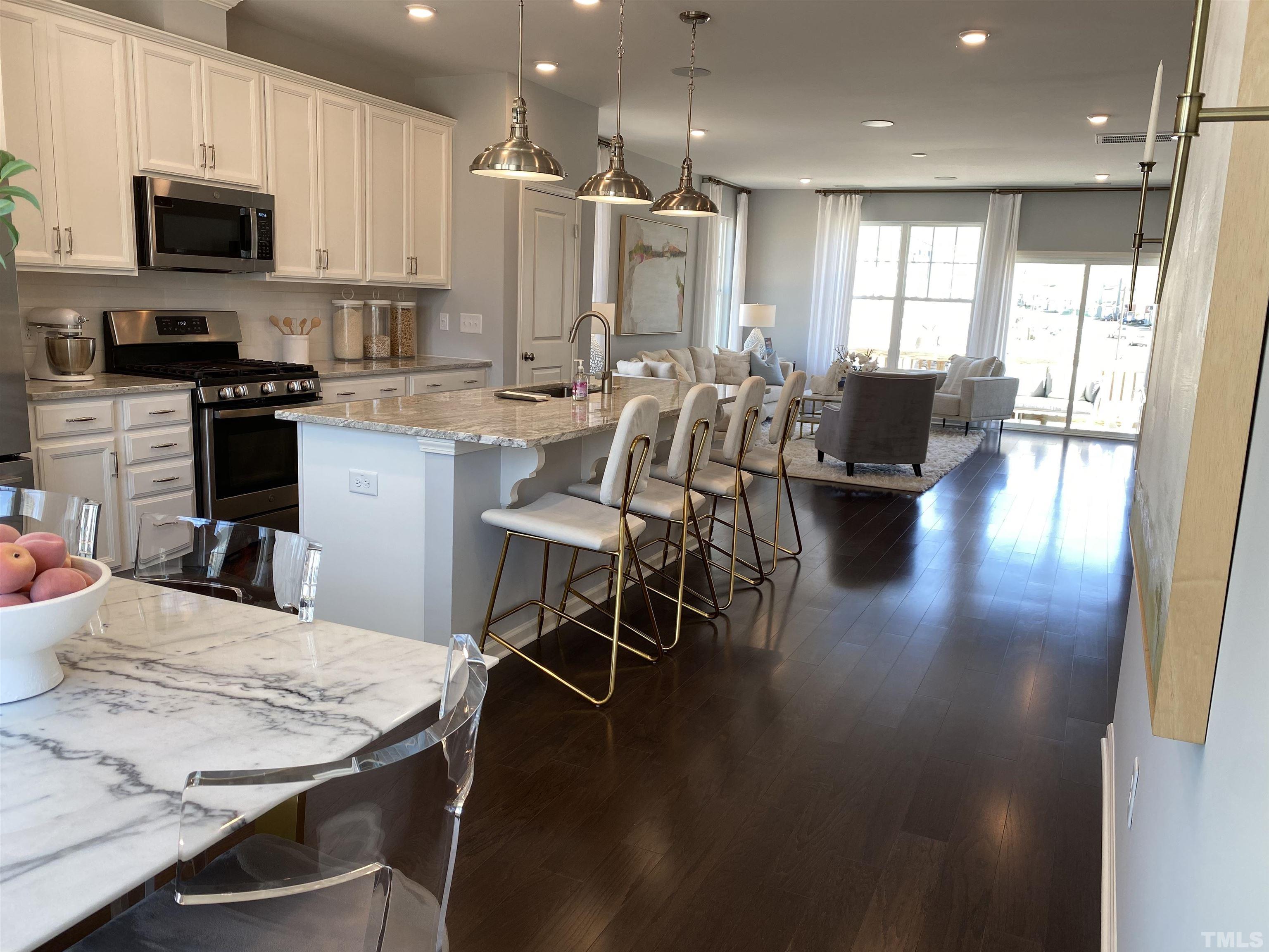 1258 Commack Drive Durham, NC 27703 - Photo 9 of 68 a kitchen with stainless steel appliances kitchen island granite countertop a stove a table and chairs in it