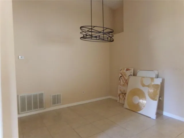a view of a room with a hanging light and kitchen