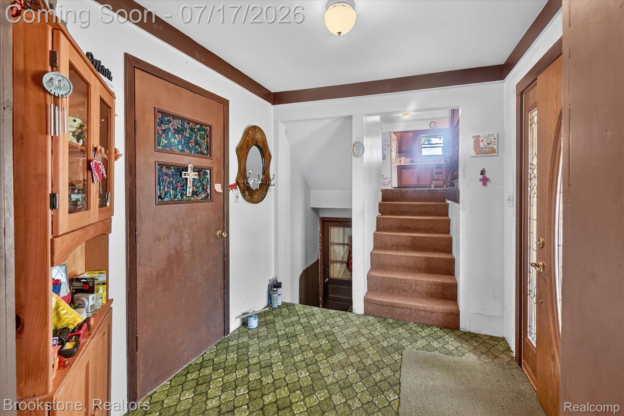 22025 Lakefield Road Merrill, MI 48637 - Photo 32 of 47 Entryway featuring a carpeted staircase, patterned green carpet flooring, and a ceiling-mounted light fixture