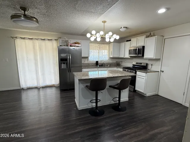 a kitchen with stainless steel appliances a dining table chairs and chandelier