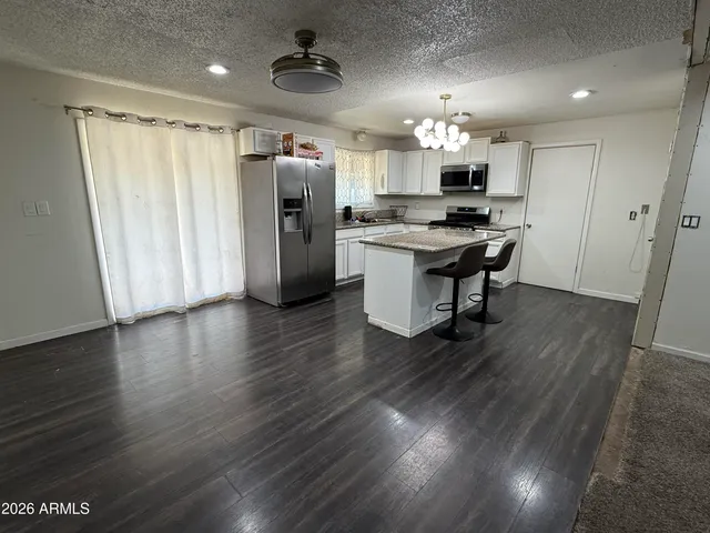 a kitchen with stainless steel appliances kitchen island hardwood floor and a sink