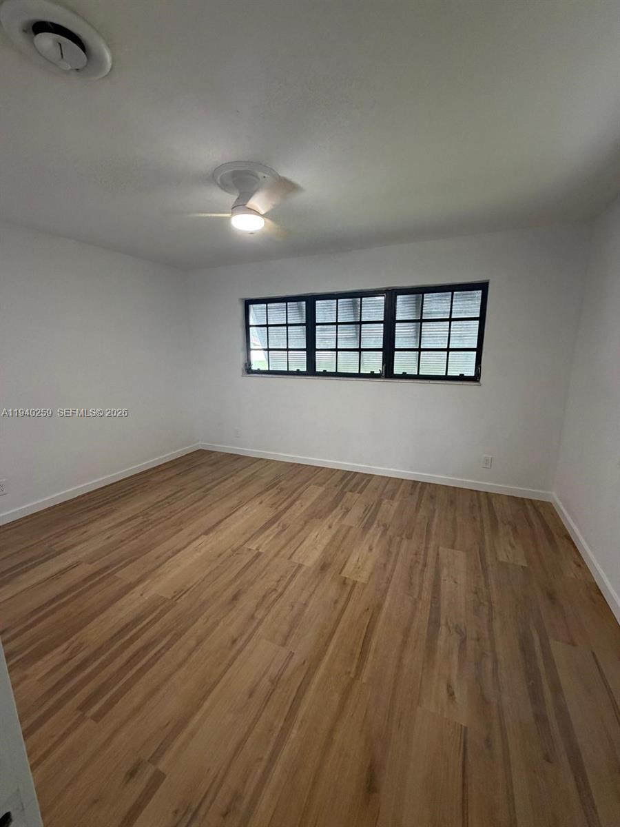 238 Southeast 3rd Street Dania Beach, FL 33004 - Photo 12 of 15 an empty room with wooden floor and windows