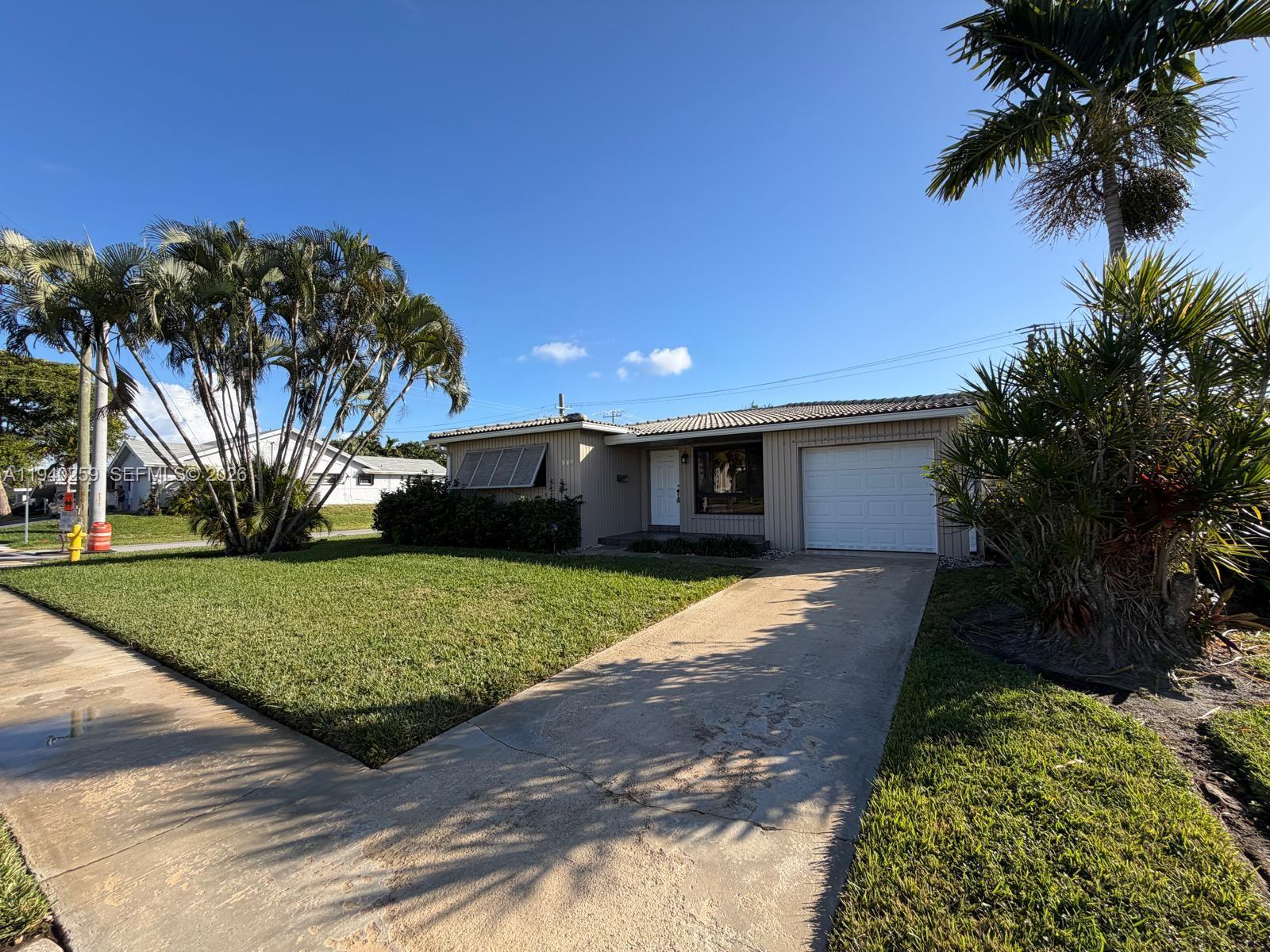 238 Southeast 3rd Street Dania Beach, FL 33004 - Photo 2 of 15 a front view of a house with a yard and garage