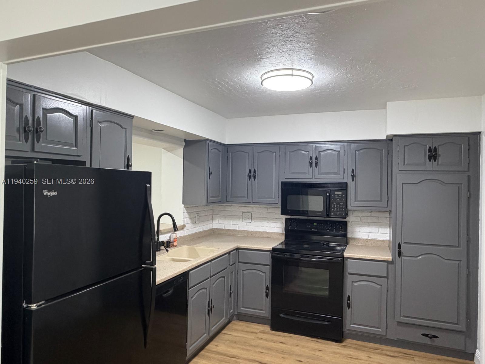 238 Southeast 3rd Street Dania Beach, FL 33004 - Photo 7 of 15 a kitchen with a refrigerator and a sink