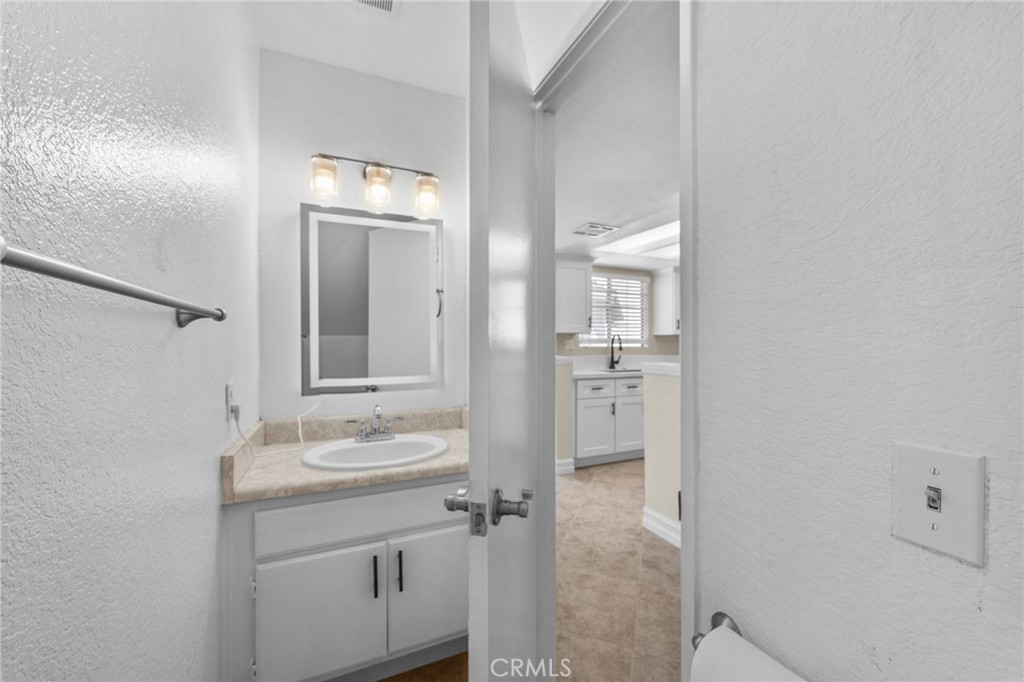 174 West Walnut Avenue, Unit B Rialto, CA 92376 - Photo 13 of 25 a bathroom with a double vanity sink and a mirror