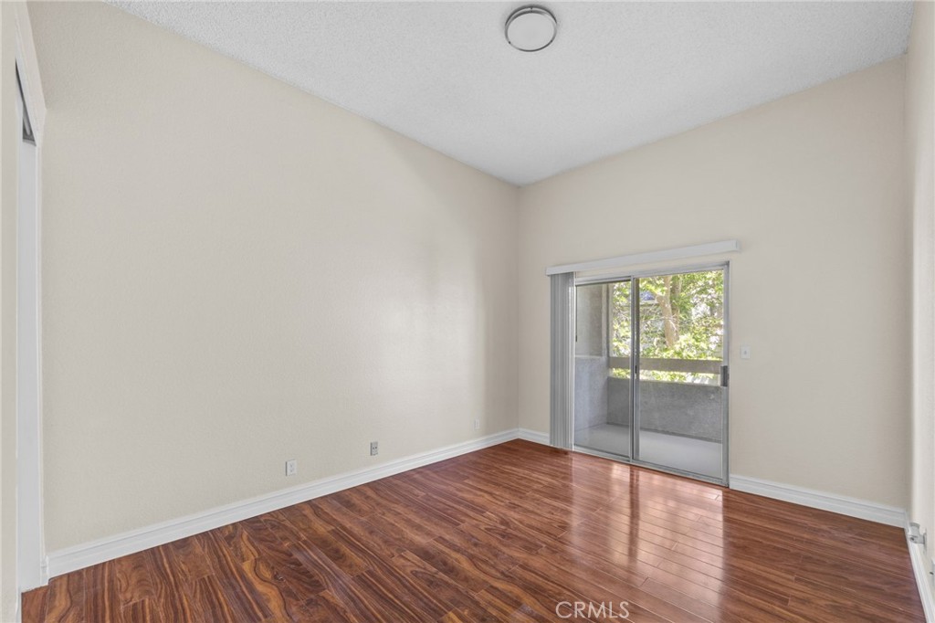 174 West Walnut Avenue, Unit B Rialto, CA 92376 - Photo 15 of 25 an empty room with wooden floor and windows