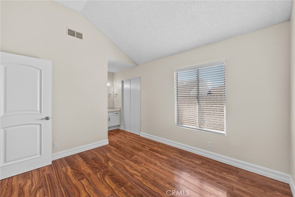 174 West Walnut Avenue, Unit B Rialto, CA 92376 - Photo 16 of 25 a view of an empty room with wooden floor and a window
