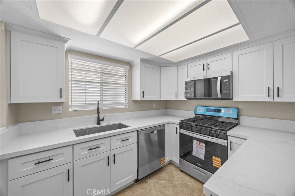 174 West Walnut Avenue, Unit B Rialto, CA 92376 - Photo 7 of 25 a kitchen with cabinets appliances a sink and a window