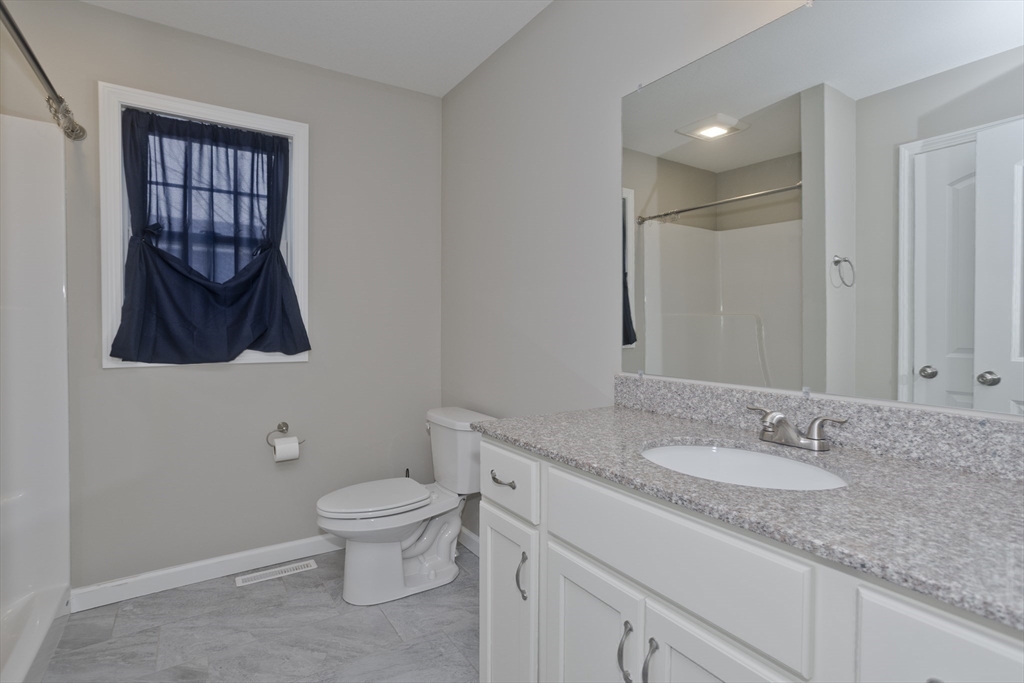 239 Gresham Street Springfield, MA 01119 - Photo 18 of 39 a bathroom with a granite countertop toilet sink and mirror