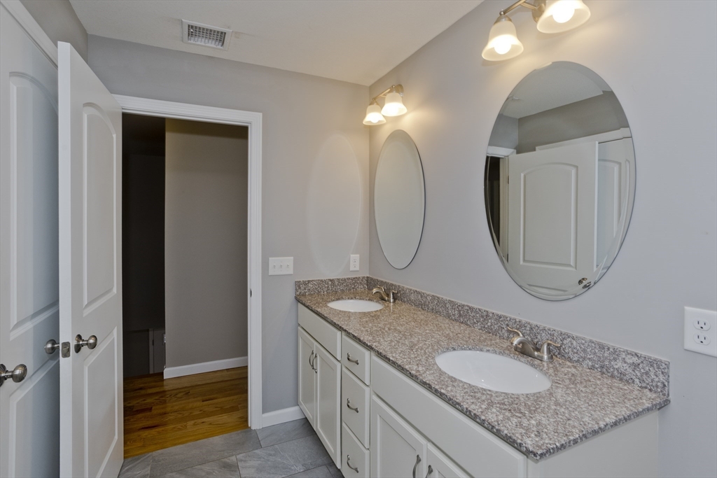 239 Gresham Street Springfield, MA 01119 - Photo 26 of 39 a bathroom with a granite countertop double vanity sinks and a mirror