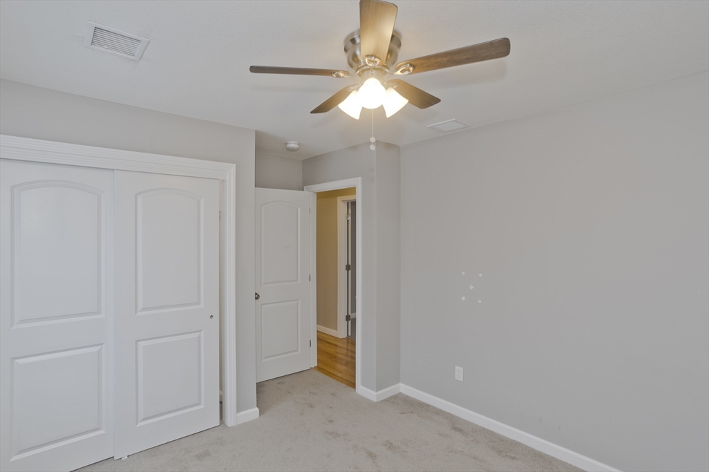 239 Gresham Street Springfield, MA 01119 - Photo 37 of 39 an empty room with a chandelier fan and closet area