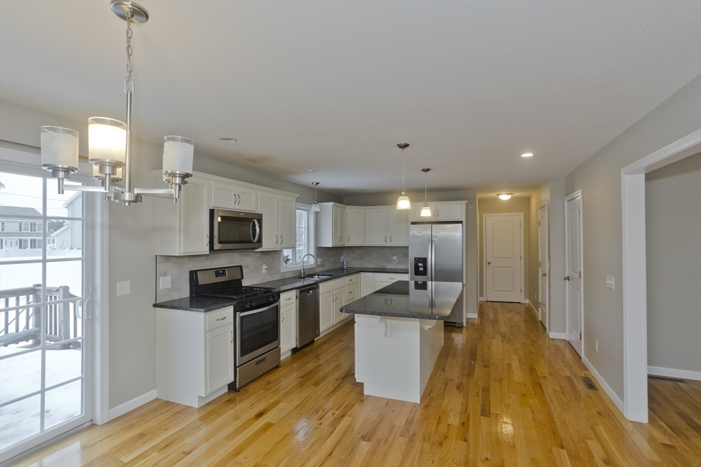239 Gresham Street Springfield, MA 01119 - Photo 6 of 39 a kitchen with stainless steel appliances kitchen island granite countertop a sink a stove and a wooden floors