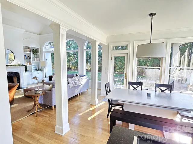 a dining room with furniture a chandelier and wooden floor
