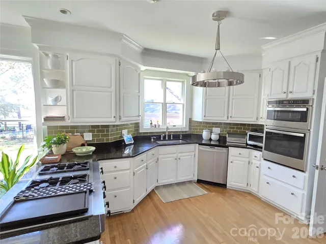 a kitchen with stainless steel appliances a stove sink and cabinets