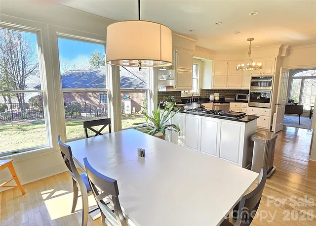 a view of a dining room with furniture a chandelier and wooden floor