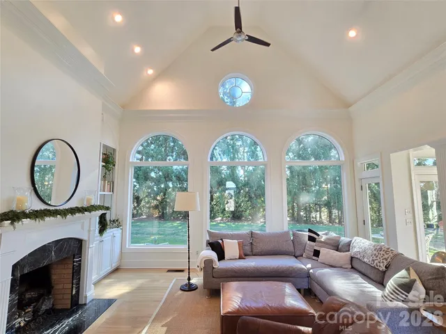 a living room with furniture a fireplace and a large window