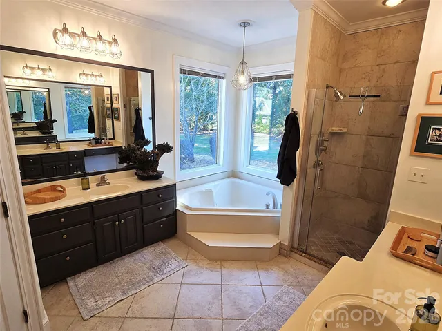 a spacious bathroom with a tub sink and mirror