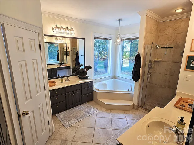 a spacious bathroom with a tub sink and mirror