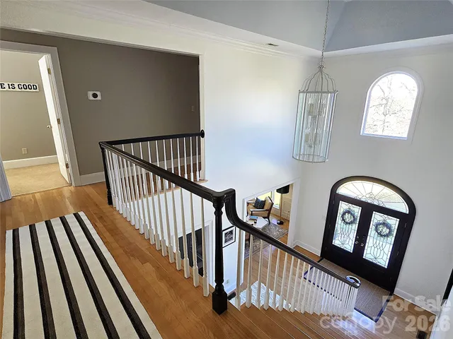 a view of staircase with lots of frames on wall and a window