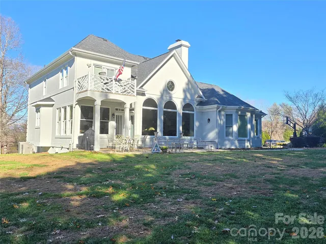 a view of a big house with a big yard and large trees