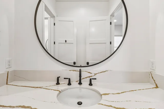 a bathroom with a sink a toilet and a mirror