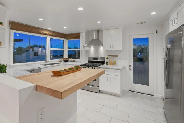 a kitchen with white cabinets and refrigerator