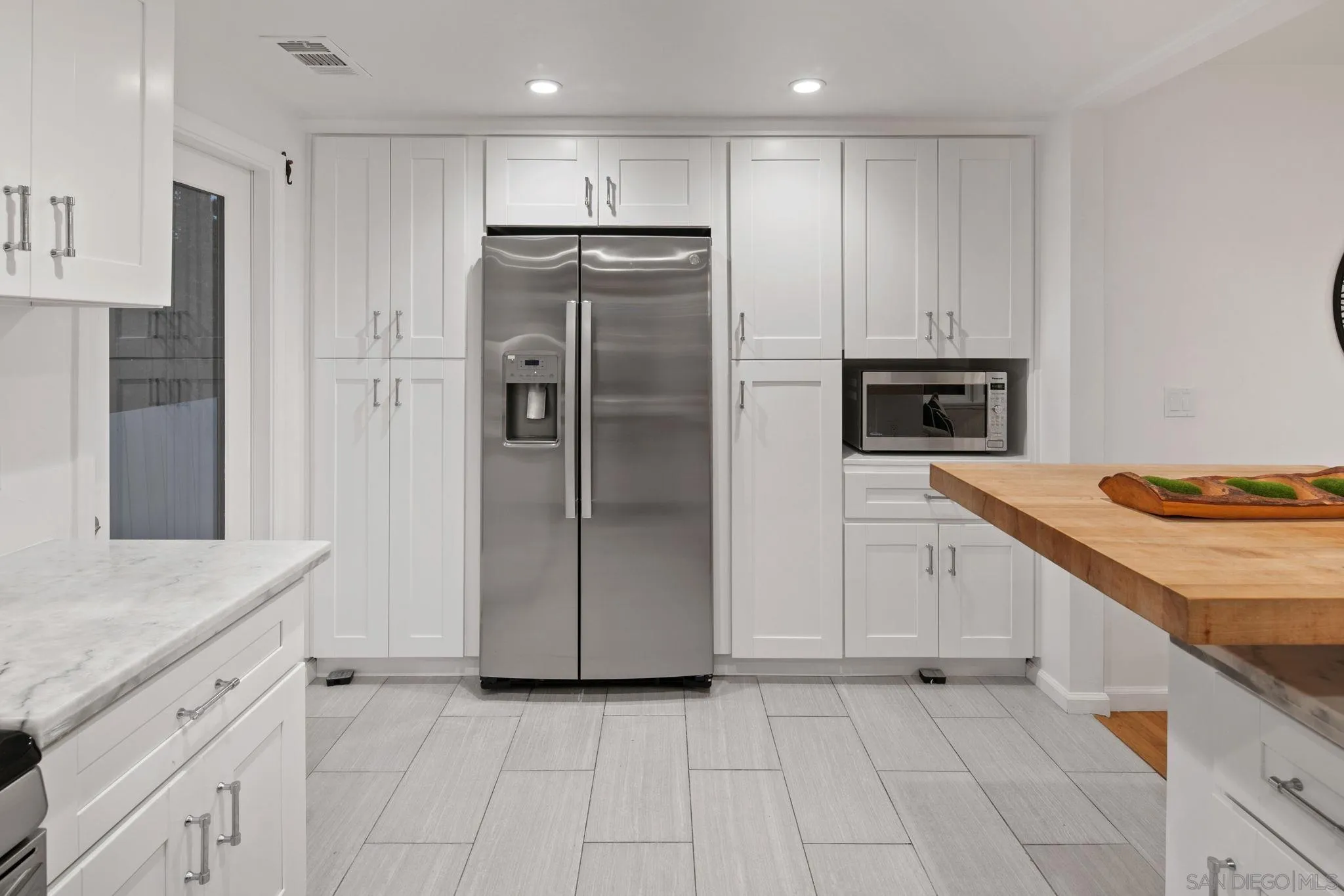 211 Ocean Street Solana Beach, CA 92075 - Photo 16 of 29 a kitchen with white cabinets and refrigerator