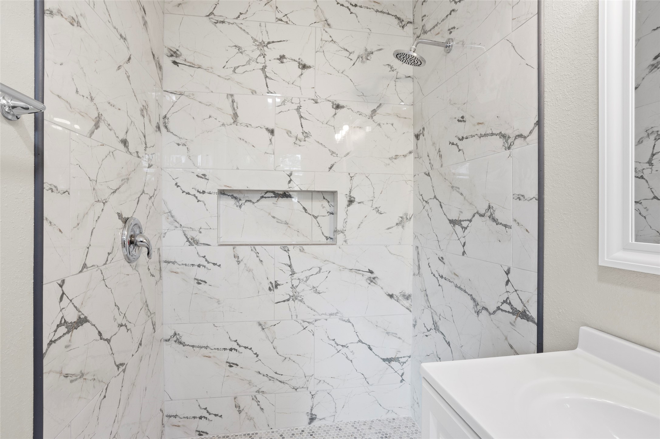 10127 Tolman Street Houston, TX 77034 - Photo 16 of 27 The large walk-in shower is lined with large-format, white-and-gray marbled tiles that extend to the ceiling.