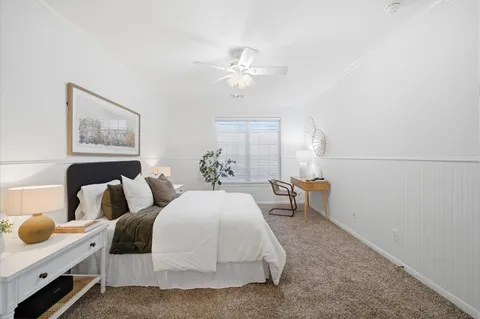 a spacious bedroom with a bed and a chandelier
