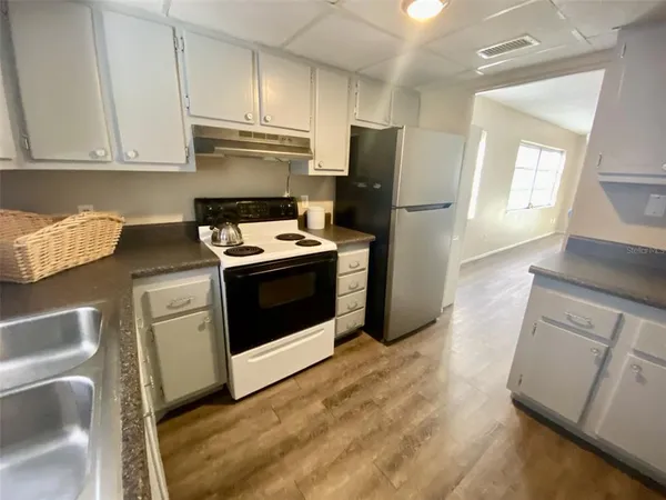 a kitchen with a stove refrigerator and microwave