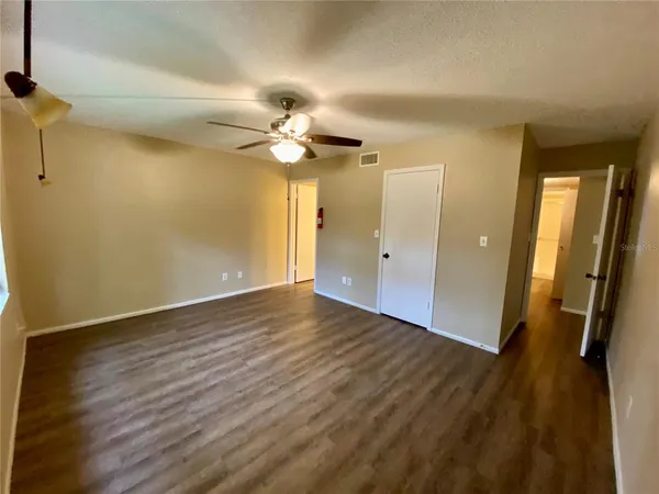 a view of an empty room with wooden floor