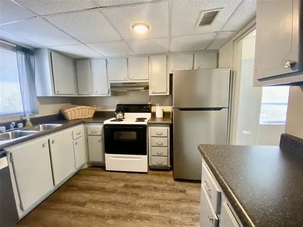 a kitchen with a refrigerator a stove top oven a sink and cabinets